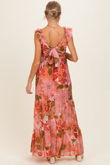 woman wearing a pink floral maternity maxi dress with ruffled sleeves and a tied open back