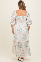 woman wearing a floral maternity plus maxi dress with puff sleeves and a smocked back, showing a baby bump