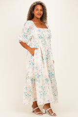 woman wearing a floral plus-size maxi dress with puff sleeves and pockets, standing in a light and airy pose