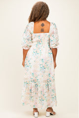 woman wearing a floral print plus size maxi dress with a smocked back and puff sleeves, showing a tattoo on her back