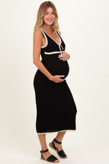 woman wearing a black maternity dress with a v-neck and white trim, holding her baby bump