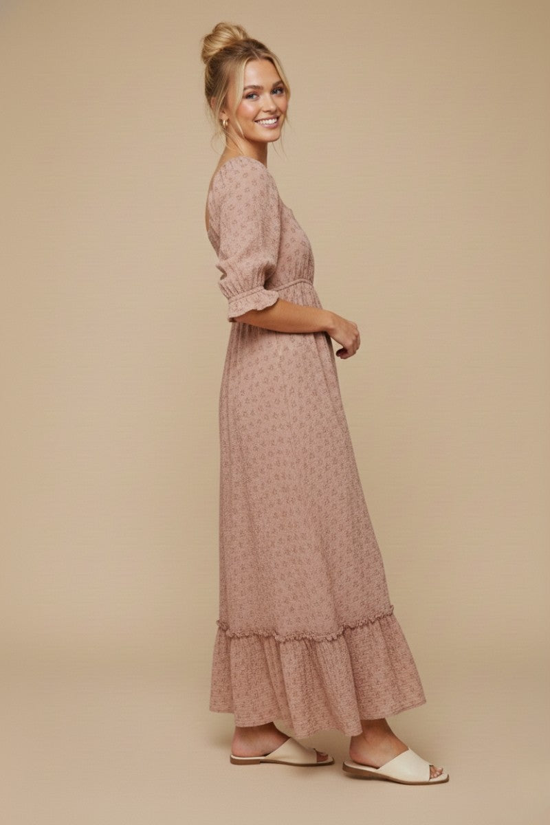 woman wearing a pink floral maxi dress with puff sleeves and a ruffled hem, styled with white sandals