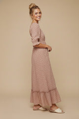 woman wearing a pink floral maxi dress with puff sleeves and a ruffled hem, styled with white sandals