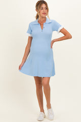 woman wearing a light blue ribbed maternity dress with white collar and sleeves, highlighting her baby bump
