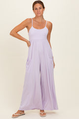 woman wearing a lavender sleeveless jumpsuit with wide legs and side pockets