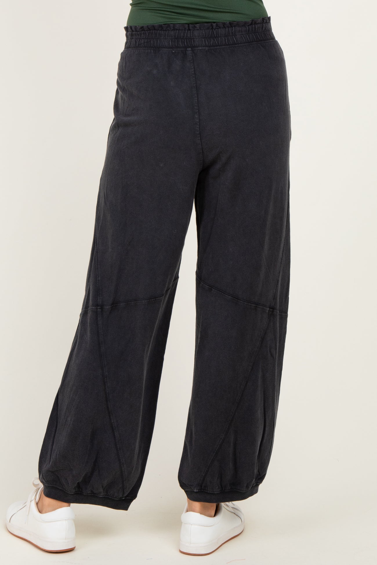 woman wearing black wide-leg pants with an elastic waistband and gathered cuffs, view from the back