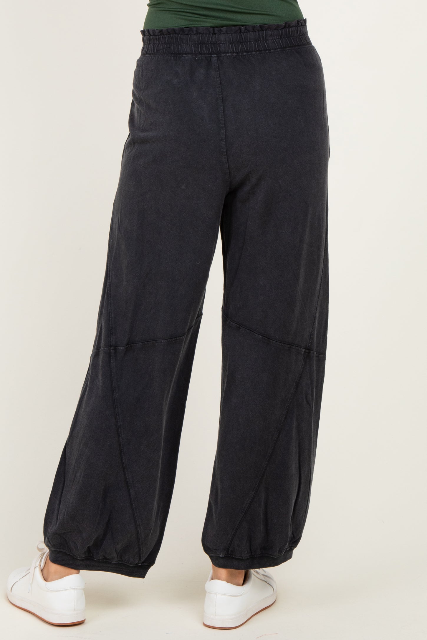woman wearing black wide-leg pants with an elastic waistband and gathered cuffs, view from the back