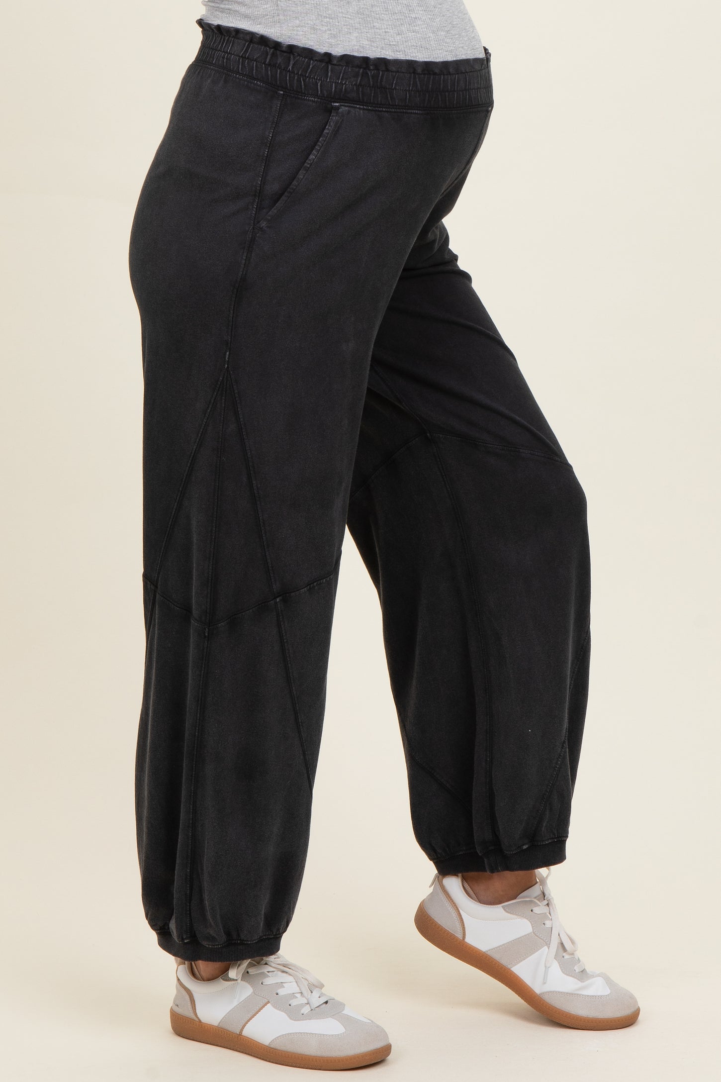 woman wearing black maternity jogger pants with side details and a visible baby bump