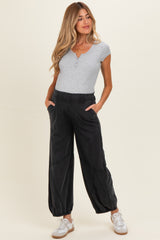 woman wearing a gray short sleeve henley shirt and black maternity jogger pants with pockets