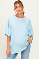 woman wearing a light blue oversized maternity t-shirt with short sleeves and a relaxed fit, showing her baby bump