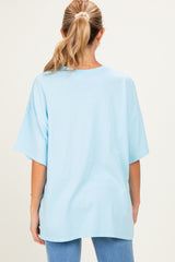 woman wearing a light blue oversized maternity t-shirt and blue jeans, showing a relaxed fit from the back
