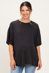 woman wearing a dark gray oversized maternity t-shirt and blue jeans with a visible baby bump