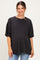 woman wearing a dark gray oversized maternity t-shirt and blue jeans with a visible baby bump
