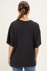 woman wearing a black oversized maternity t-shirt, seen from the back, paired with blue jeans