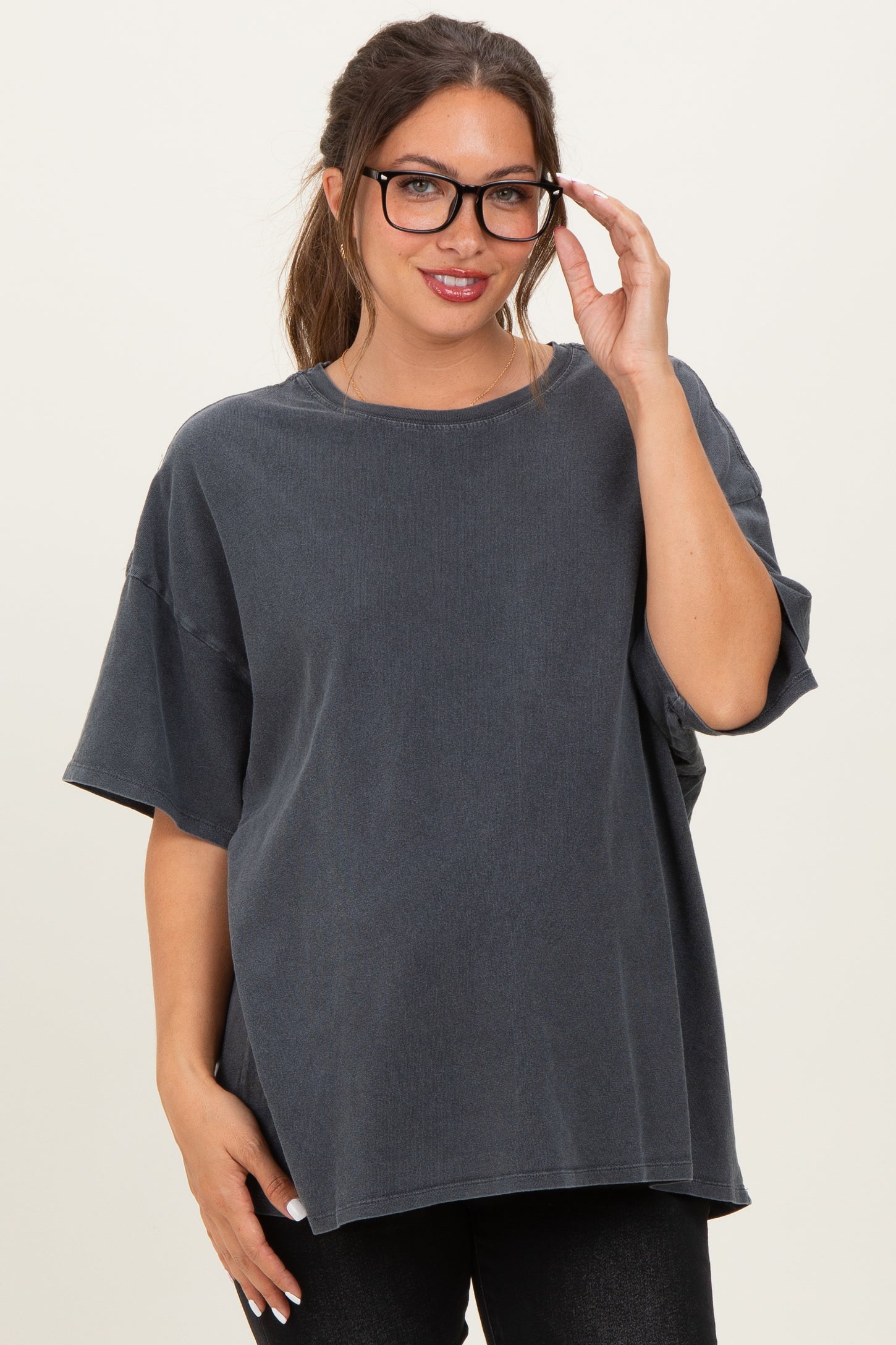 woman wearing a dark gray oversized maternity t-shirt with short sleeves and stylish glasses