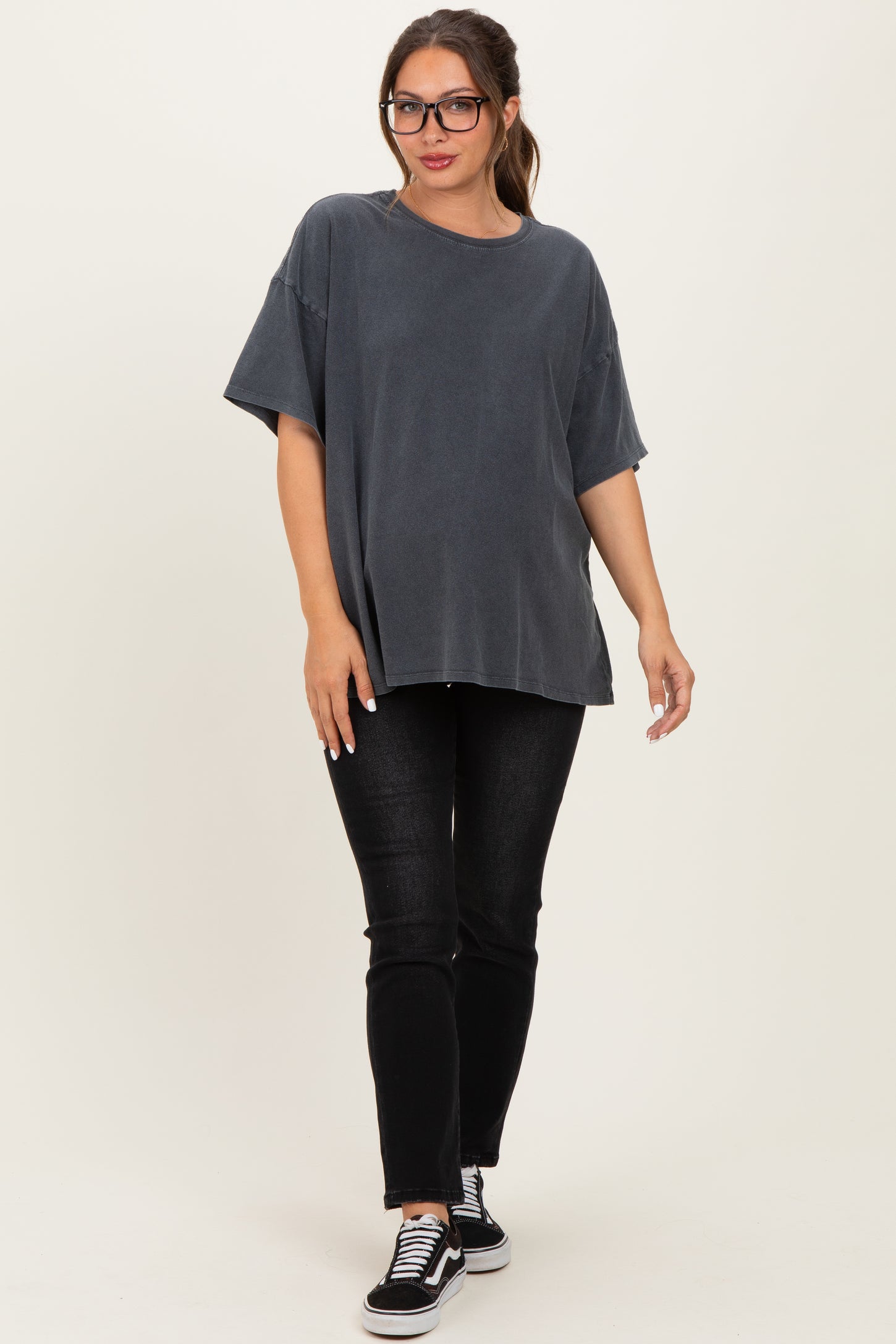 woman wearing a dark grey oversized maternity t-shirt and black skinny jeans with sneakers