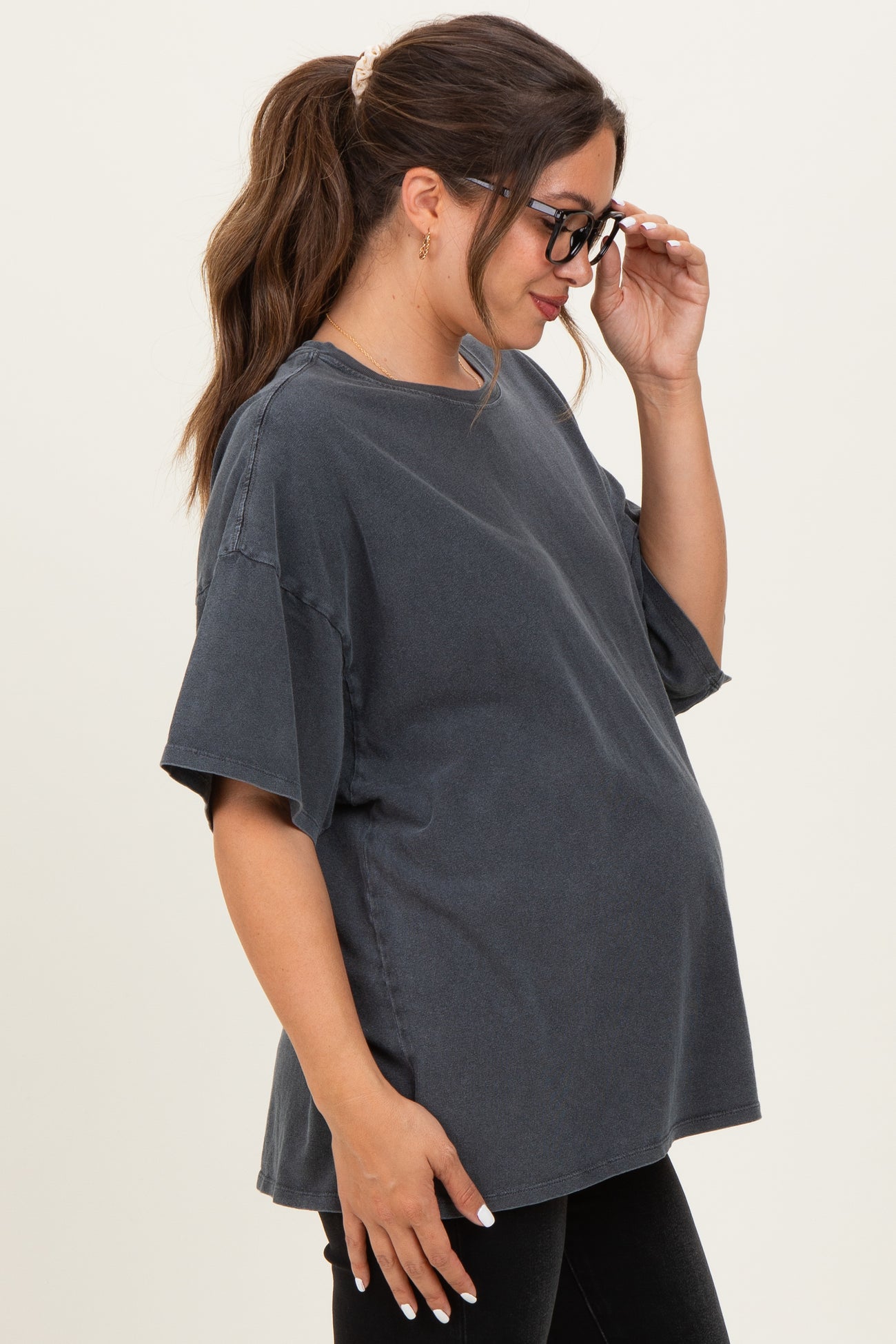 woman wearing a charcoal oversized maternity t-shirt with a visible baby bump and glasses