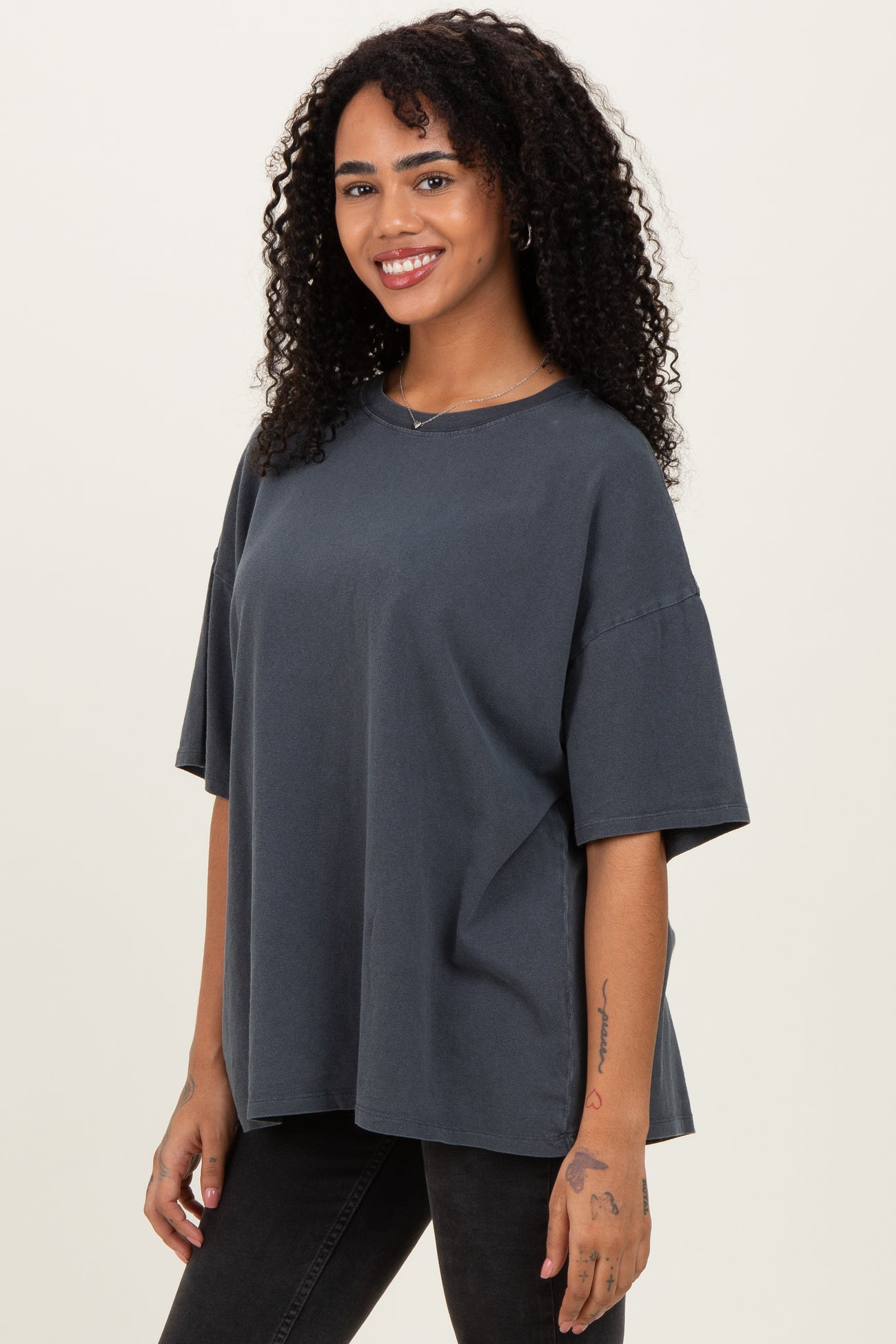 woman wearing a dark gray oversized t-shirt with a relaxed fit and short sleeves