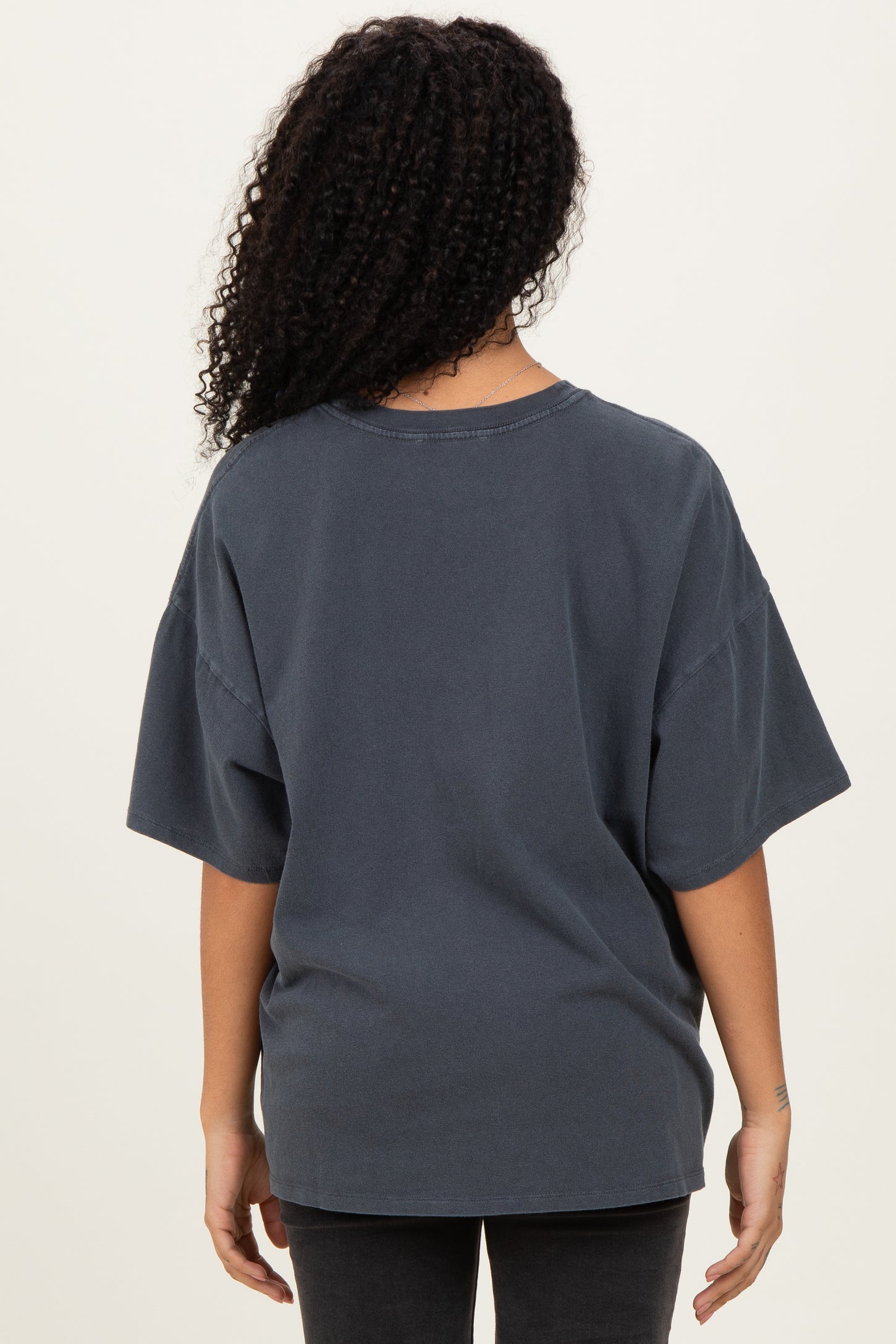 woman wearing a charcoal oversized short sleeve t-shirt seen from the back