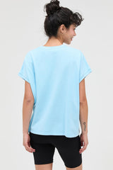 woman wearing a light blue oversized t-shirt and black bike shorts from the back