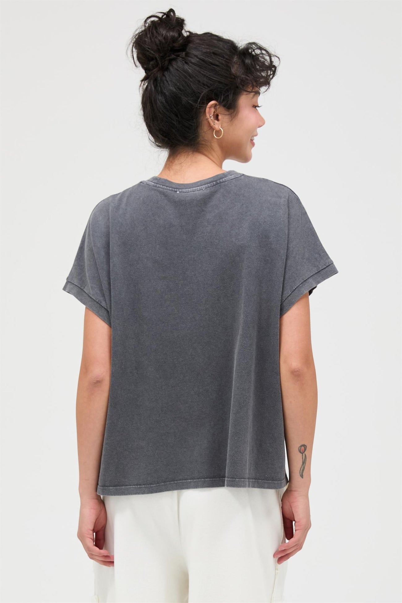 woman wearing a relaxed fit gray oversized t-shirt with short sleeves and a round neckline