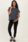 woman wearing a dark gray maternity top and black leggings, holding her baby bump