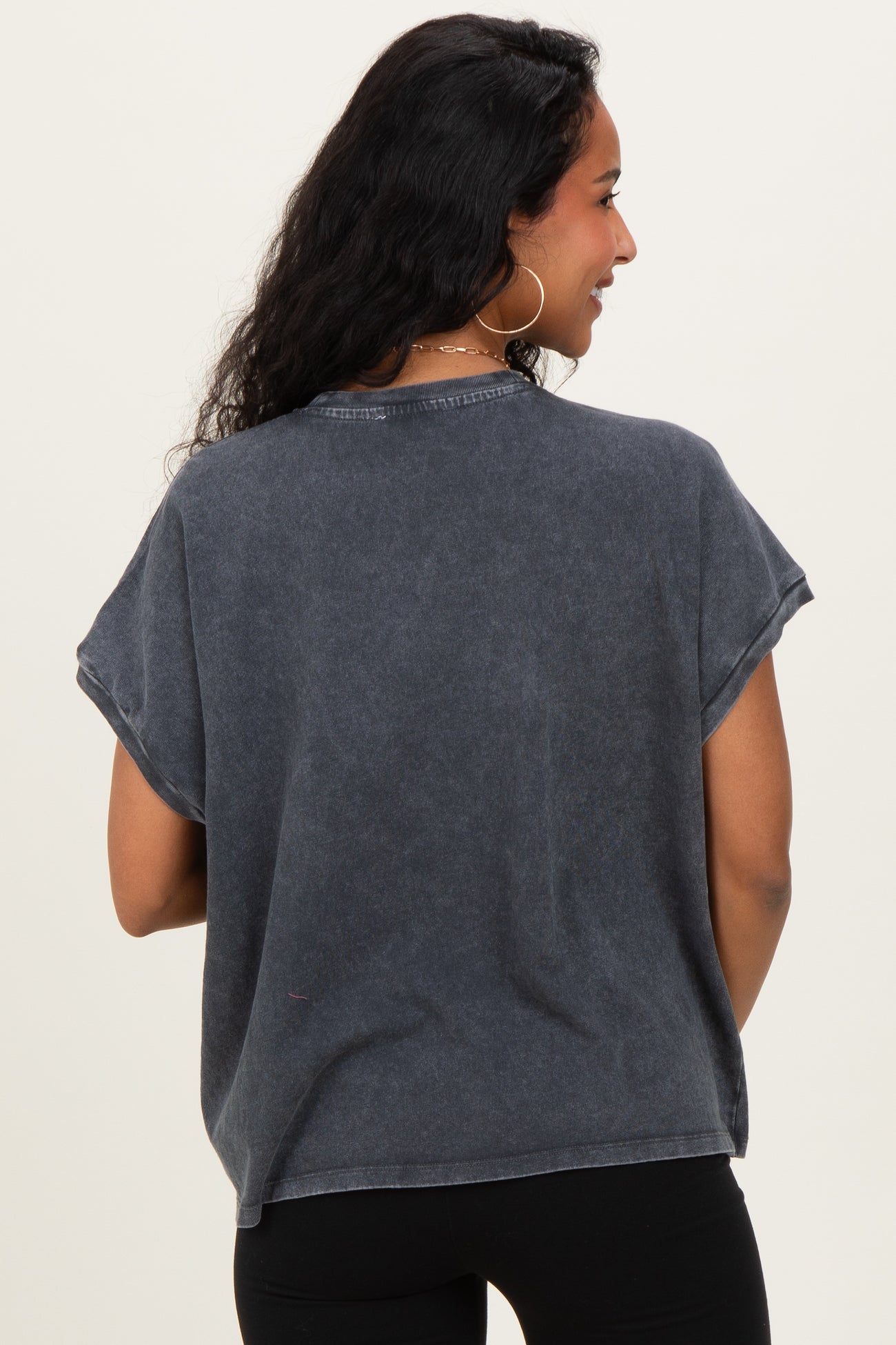 woman wearing a dark gray short sleeve maternity top, showing the back view with a relaxed fit