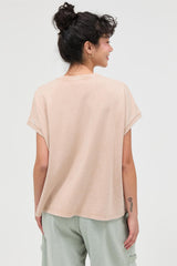 woman wearing a beige oversized short sleeve top viewed from the back
