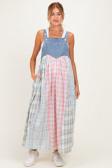 woman wearing a denim maternity dress with a colorful plaid skirt and pockets, styled for a relaxed fit