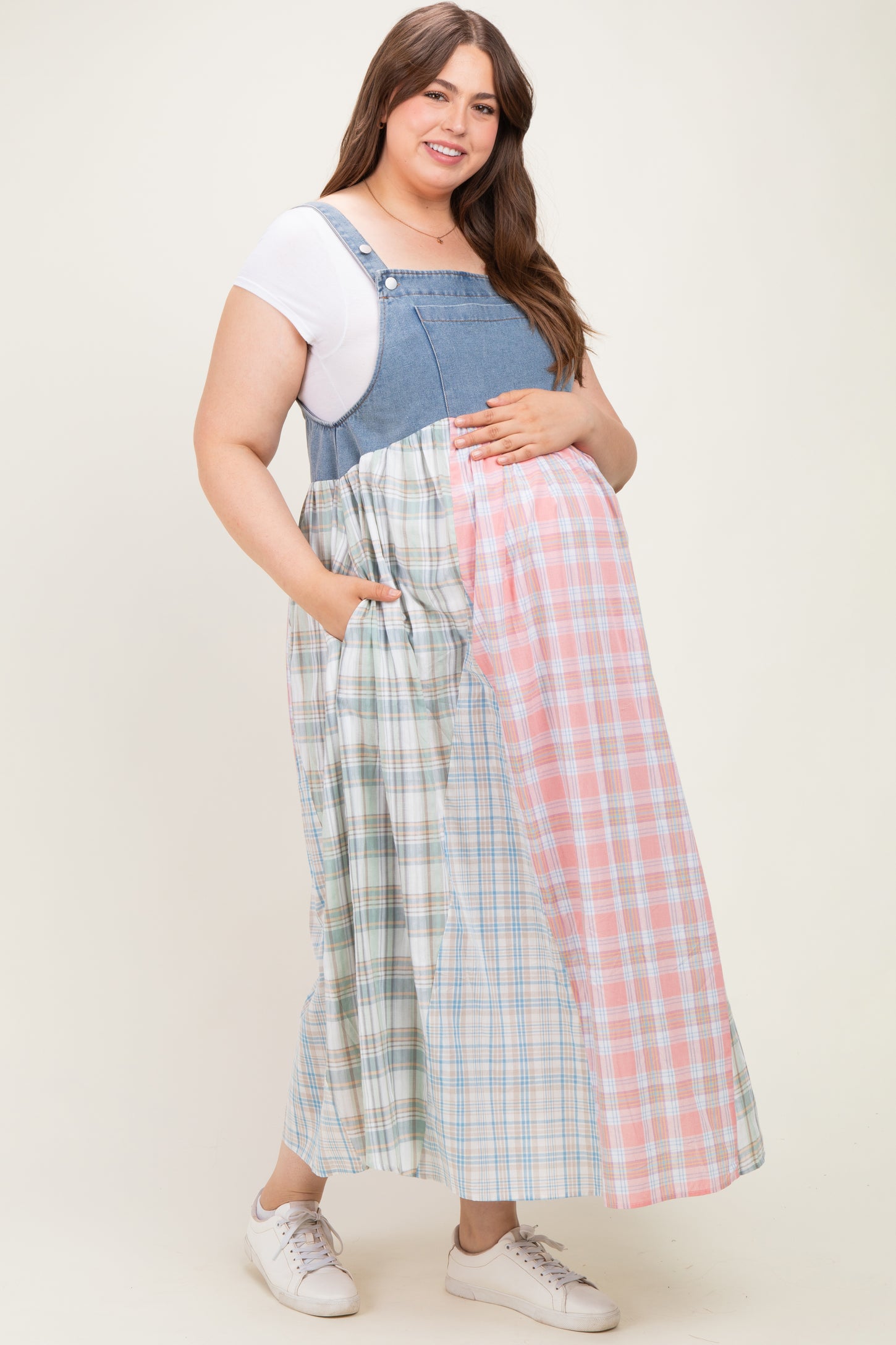 woman wearing a denim and plaid maternity dress with pockets and a visible baby bump
