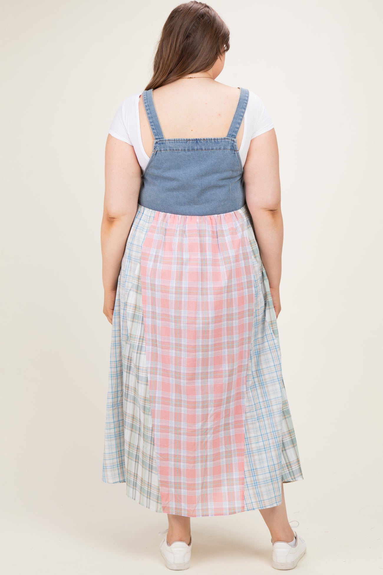 woman wearing a denim and plaid maxi dress from the back, showing a mix of pastel colors and a flowing fit, maternity wear