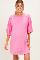 woman wearing a pink oversized maternity dress with short sleeves and a relaxed fit