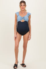 woman wearing a blue and navy striped maternity swimsuit with ruffle sleeves and a keyhole cutout