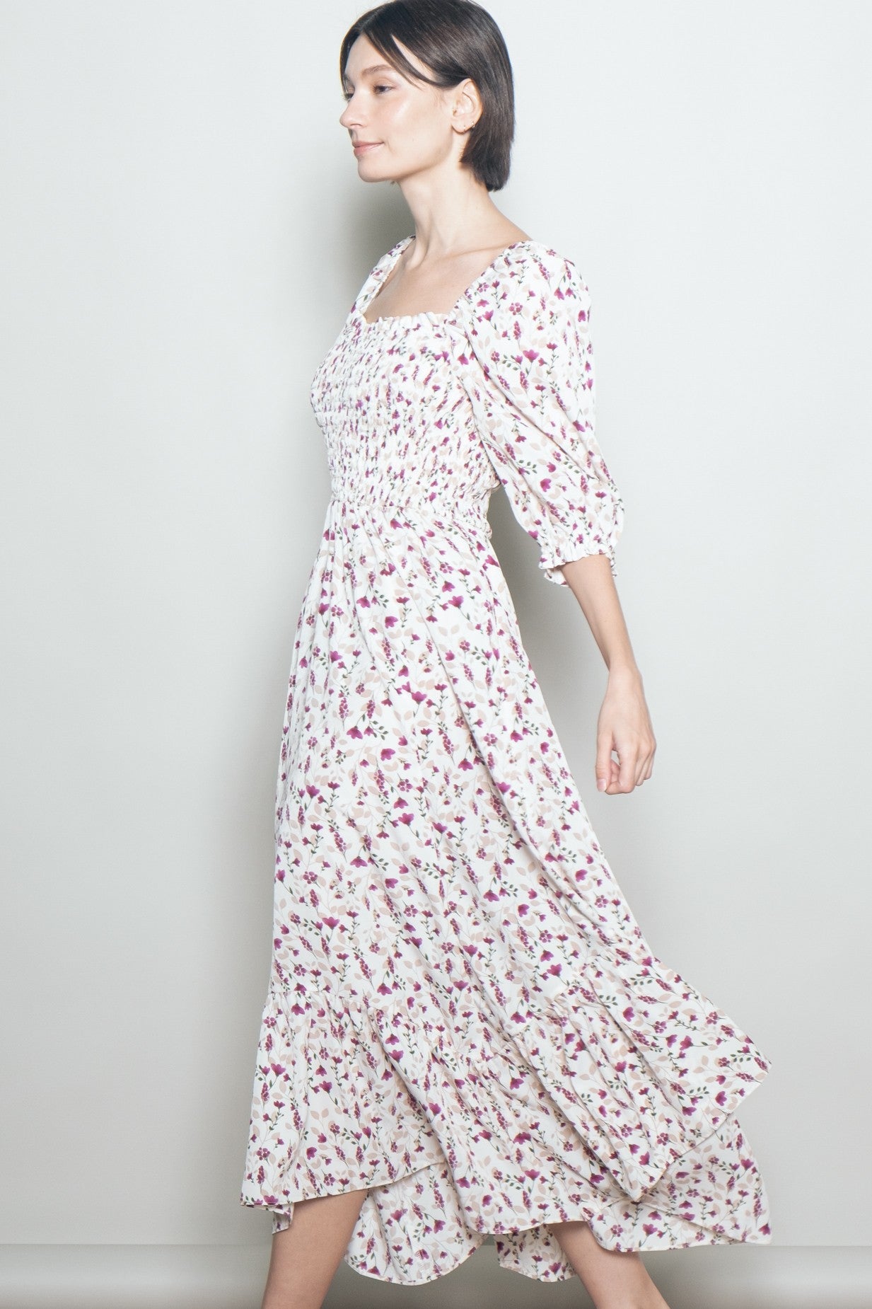 woman wearing a floral midi dress with a square neckline and puff sleeves, walking gracefully