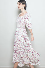 woman wearing a floral midi dress with a square neckline and puff sleeves, walking gracefully