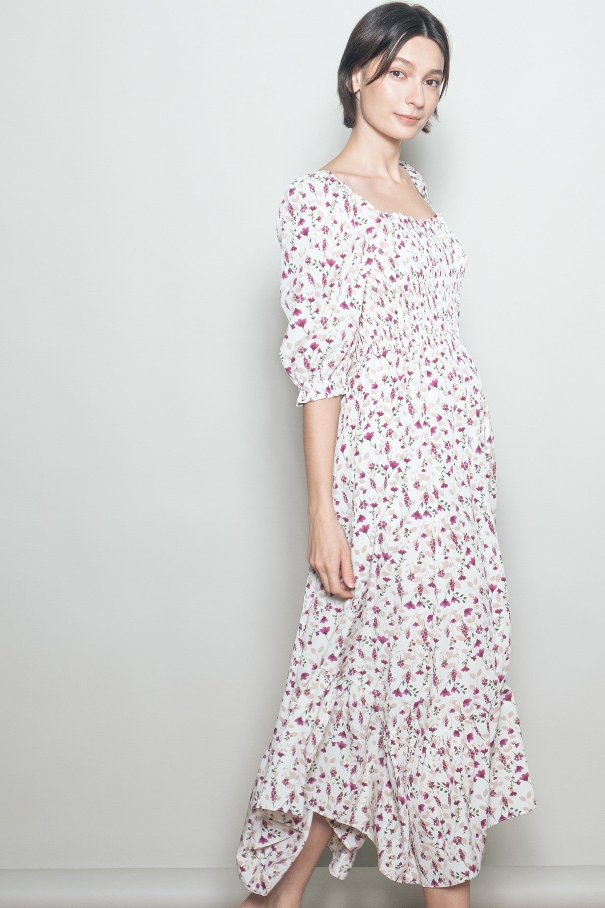 woman wearing a white floral smocked maxi dress with puff sleeves and a tiered skirt