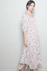 woman wearing a white floral smocked maxi dress with puff sleeves and a tiered skirt