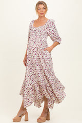 woman wearing a floral maternity dress with a square neckline, smocked bodice, and ruffled hem, showcasing a baby bump