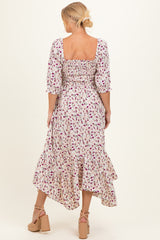 woman wearing a floral maternity maxi dress with puff sleeves and a ruffled hem, showing a baby bump from the back