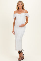 woman wearing a white off-the-shoulder maternity dress with lace details and holding her baby bump
