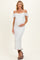 woman wearing a white off-the-shoulder maternity dress with lace details and holding her baby bump