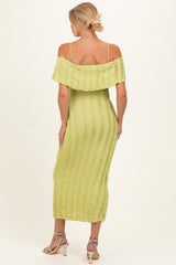 woman wearing a light green off-the-shoulder maternity dress with a textured design and a fitted silhouette