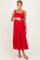 woman wearing a red maternity dress with square neckline and tiered hem, holding her baby bump