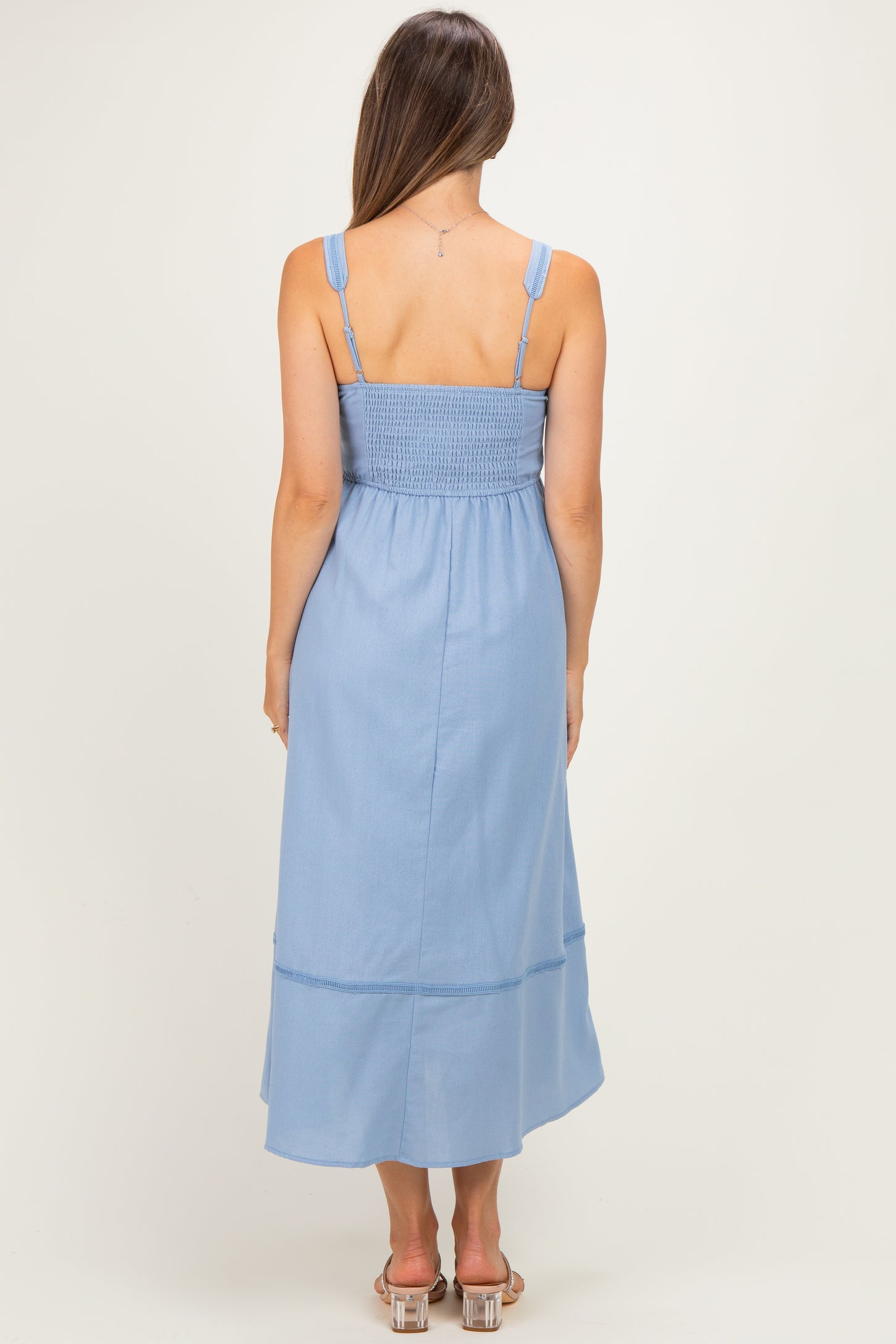 woman wearing a light blue maternity maxi dress with a smocked back and adjustable straps