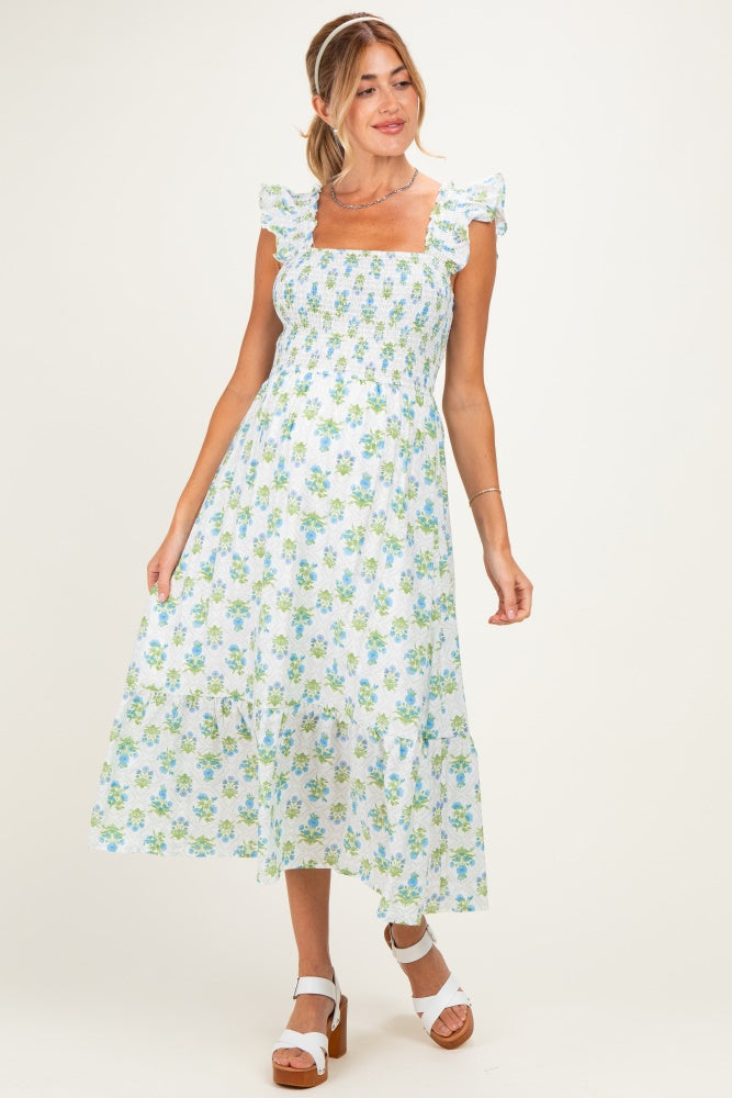 woman wearing a floral print maternity dress with ruffled sleeves and a smocked bodice