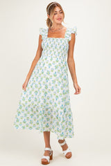 woman wearing a floral print maternity dress with ruffled sleeves and a smocked bodice
