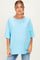 woman wearing a light blue oversized maternity top with short sleeves and a relaxed fit