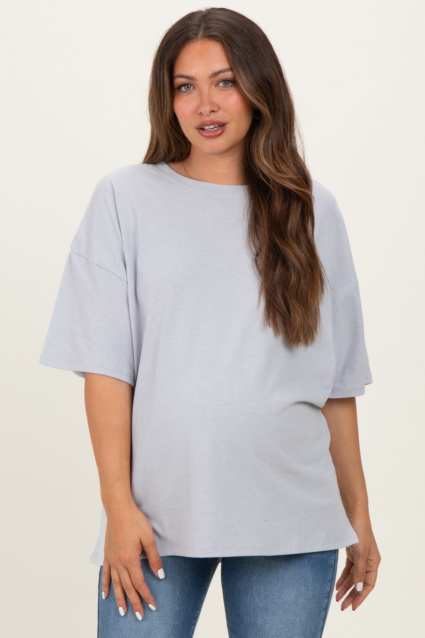 woman wearing a light grey oversized maternity t-shirt with short sleeves and a visible baby bump