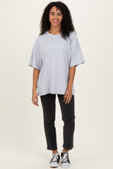 woman wearing a light gray oversized t-shirt and black cropped jeans with white sneakers