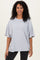 woman wearing an oversized light gray t-shirt with short sleeves and a relaxed fit